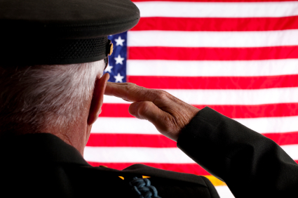 Senior military man in uniform saluting the 50 star American flag.